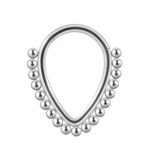 Macro detail of a silver stainless steel septum ring featuring a unique droplet shape