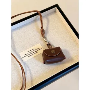 Mini collana a sacchetto in pelle marrone scuro con cordino intrecciato e bottone retrò
