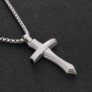 Vue détaillée du pendentif croix en argent avec finition sablée sur fond noir