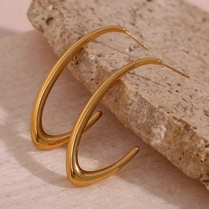 Detail of minimalist gold V-shaped curved drop earrings with a high polished mirror finish