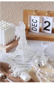 Close-up of clear acrylic Christmas ornaments including Eiffel Tower and bell with glitter