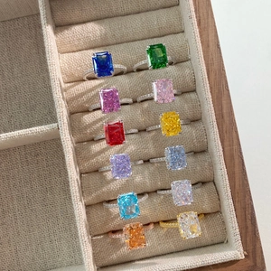 Collection of S925 sterling silver rings with colorful square-cut stones in a box