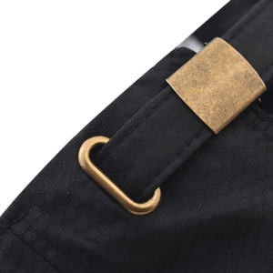 Detail of black quick-dry hat with honeycomb texture and bronze metal adjustment buckle