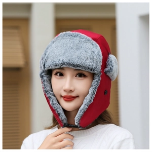 Detail of red windproof winter hat with thick grey faux fur lining and buckle strap