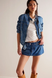 Dettaglio del set denim blu scuro con giacca corta e minigonna abbinata