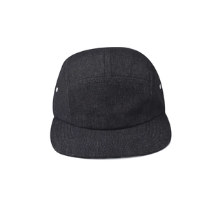 Detail of a black five-panel camper hat featuring side metal eyelets and premium denim texture