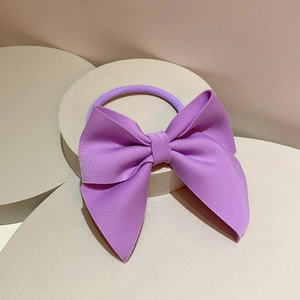 Macro detail of lavender ribbed fabric bow hair tie with high-quality textured finish