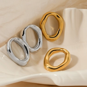 Minimalist irregular oval stainless steel earrings in gold and silver finishes on a tray