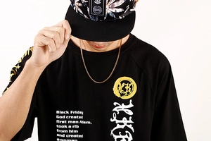 Detailansicht eines schwarzen Baumwoll-T-Shirts mit gold-weißem Grafik-Textdruck