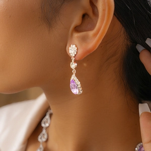 Gros plan d'élégantes boucles d'oreilles argentées avec cristaux violets en goutte
