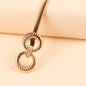 Detailed macro view of a gold double-ring interlocking buckle with elastic metal chain belt