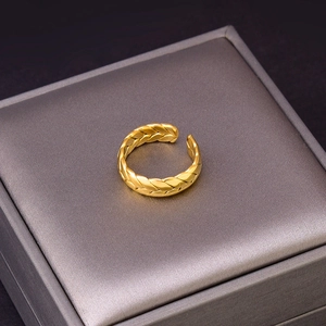 Golden woven wheat pattern open ring displayed on a professional jewelry box lid