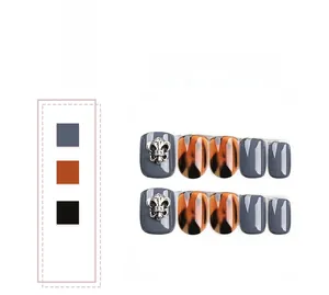 Detailed view of grey and tortoiseshell press-on nails with silver metal cross design