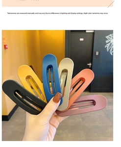 Detailed view of large matte candy-colored hair clips in black, blue, and pink set
