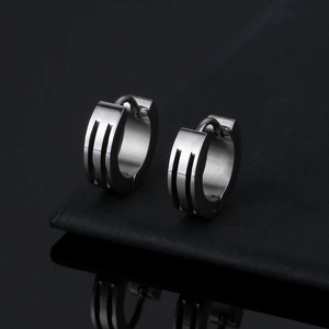 Pair of silver titanium steel hoop earrings with three-line groove design on black background