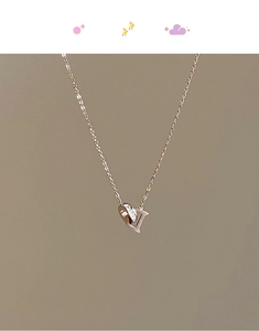 Détail du collier en or rose avec pendentif double anneau lettre D et cristaux brillants