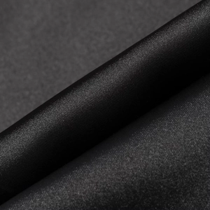 Gros plan macro d'un tissu en soie noire haut de gamme montrant texture lisse et éclat satiné