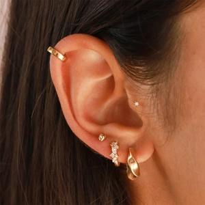 Detailed view of layered gold S925 silver hoop earrings and ear cuffs with cubic zirconia