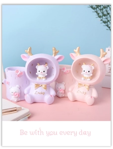 Macro detail of cute resin bunny pen holder with lucky deer figurine desk decor