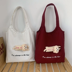 Detail of canvas tote bags with plush 3D cat dolls in white and burgundy colors