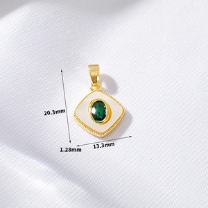 Macro view of gold-plated square pendant with green stone and pearl inlay details