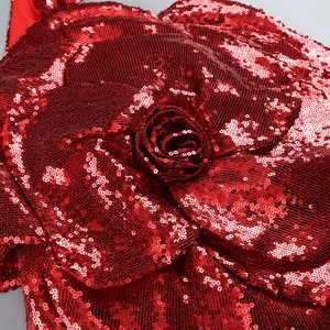 Détail de décoration de rose rouge à paillettes sur une robe sexy à une épaule
