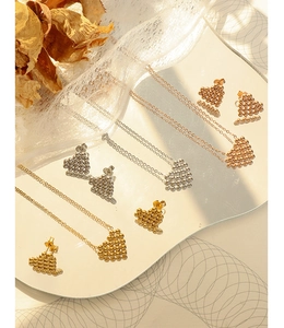 Detailed set of gold, silver, and rose gold heart jewelry on a mirror with dried flowers