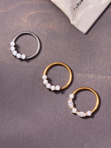 Macro detail of titanium seamless nose rings with inlaid 5A zircons in gold and silver finish