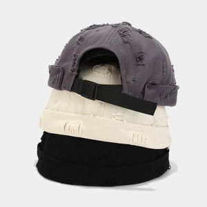 Distressed brimless beanie hats in grey, beige, and black with raw edge finish