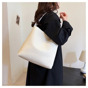 Detail of white woven texture on a large minimalist faux leather shoulder tote bag