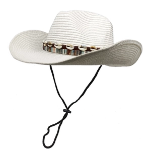 Detail of white woven straw hat featuring seashell band and black adjustable chin strap