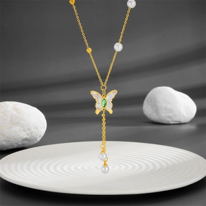 Golden butterfly necklace with white mother of pearl and green gemstone accents