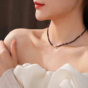 Titanium steel freshwater pearl necklace featuring red garnet beads on female model neck