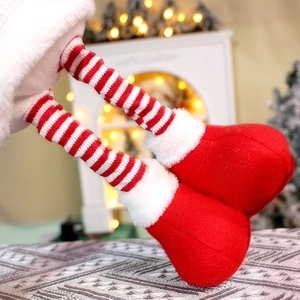 Close-up of plush red and white striped Christmas elf legs with soft white faux fur trim