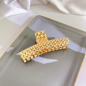 Makroaufnahme der goldenen Haarklammer aus Metall mit klassischen geometrischen Rauten