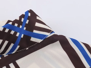 Detailed macro view of geometric print fabric in blue and brown with precise stitching