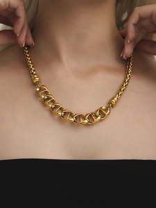 Close-up of golden pig nose chain necklace in 18K gold plated stainless steel on a model