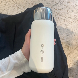 Close-up of white matte 316 stainless steel vacuum flask with silver lid