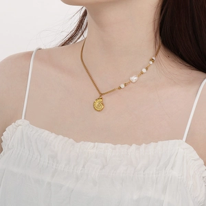 Close-up of 18K gold plated stainless steel necklace with Baroque pearl and shell pendant