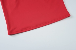 Detailansicht der präzisen Nähte am roten Saum eines stilvollen Sommer-Strandkleids