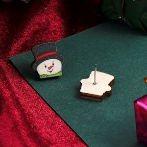 Detailed macro view of wooden snowman stud earrings with metal posts and festive backing