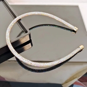 Macro view of thin headband with iridescent rhinestones and gold metal tips
