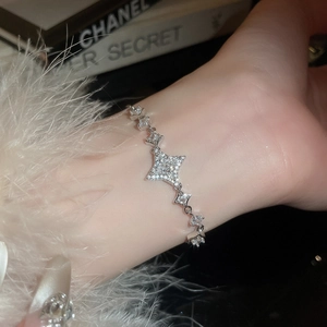 Detail of silver star-link bracelet with shimmering crystals on a wrist