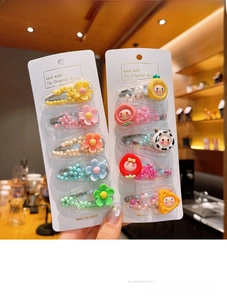Close-up of cute fruit and flower hair clips featuring 3D strawberry and cow patterns