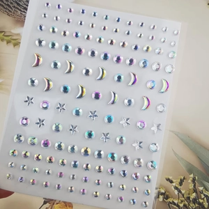 Macro view of iridescent moon and star face gems on a transparent backing sheet