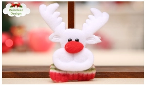 Detailed view of a soft white plush reindeer Christmas brooch with red nose and knit accents