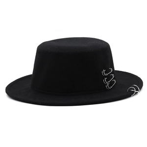Detail view of black wool fedora with punk style silver rings and safety pin accents