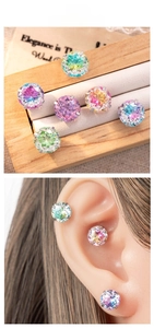 Macro detail of round gradient zircon earrings in multi-color claw-set titanium steel