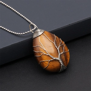 Macro view of teardrop tiger eye stone pendant with silver wire tree of life wrap