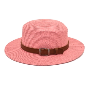 Detalle de sombrero de paja rosa con cinturón de cuero sintético marrón y hebilla metálica